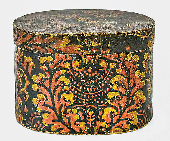The oval wallpaper box from the mid-19th century displays an overall pink and yellow floral pattern on a black ground. The 5