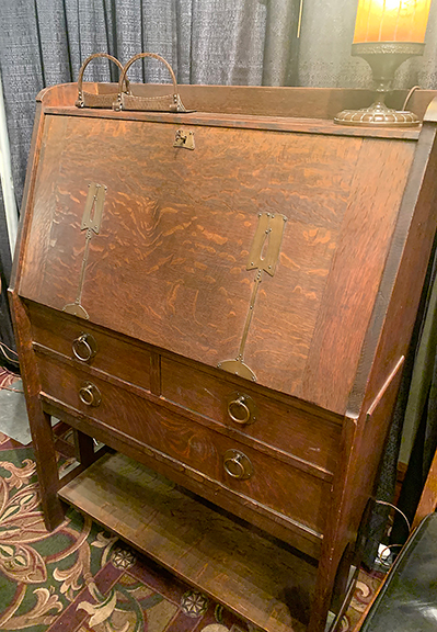 JMW Gallery, Cambridge, Massachusetts, offered this Stickley Brothers drop-front desk with strap copper hardware for $1995. Besides the cubbyholes, it has four drawers inside and two small drawers and one large drawer in the base. On top are copper Roycroft bookends for $495 and a Handel floral reverse-painted lamp for $895.