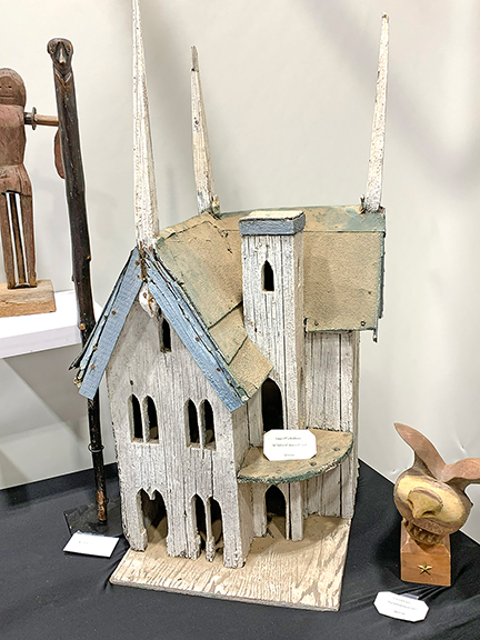 1  County Seat Antiques, Litchfield, Connecticut, showed a birdhouse resembling a church, which had contained a nest when found, priced at $550. To its left, a walking stick carved with a dog&rsquo;s head as its handle was tagged $295, and the carved eagle to the right is signed and dated &ldquo;1965&rdquo; and was tagged $475.