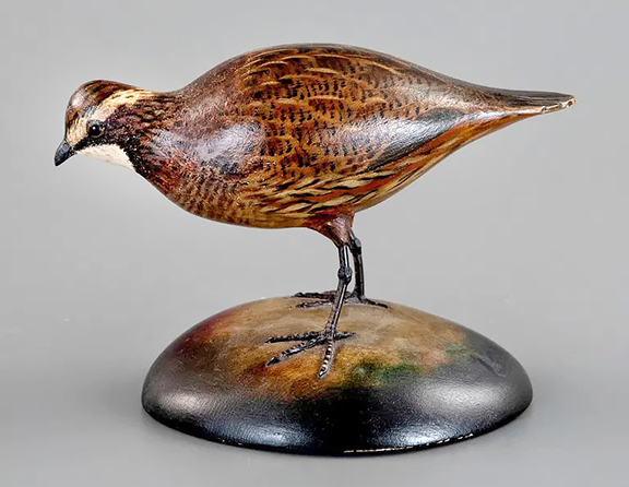 While Elmer Crowell preferred to carve and paint from live birds, many native species, including the quail, had begun to decline on Cape Cod in the early part of the 20th century. His life-size feeding bobwhite quail, circa 1930, a rare pose, exhibits Crowell’s best plumage, incised tail feathers, and two-tone glass eyes and retains Crowell’s stamp on the bottom. Crowell was known to find inspiration from his carving and painting predecessors. This bird sold for $66,000 (est. $20,000/30,000) to the same buyer who bought the upright quail. 