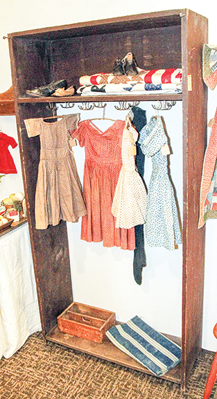 Wardrobe from the Amana Colonies in Iowa, having hardware for a homespun curtain, $695; dresses, from left: cotton, 1840s-50s, 23