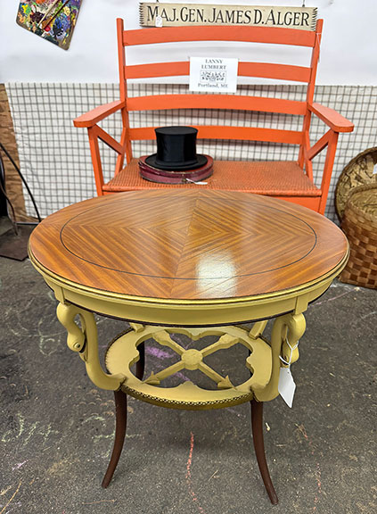 The circa 1930 table with mahogany veneer marquetry, a brass rail, and swan&rsquo;s head decoration was $325 from Lanny Lumbert of Double LL Antiques & Collectibles, Portland, Maine. The German collapsible silk top hat with box, early 20th century, was $175; the bench in salmon-colored paint was $250; and the sign &ldquo;Maj. Gen. James D. Alger,&rdquo; who was known as &ldquo;Gentleman Jim&rdquo; when he was at West Point (Class of 1935), was $60. Alger attended Gould Academy in Bethel, Maine. The bench sold.