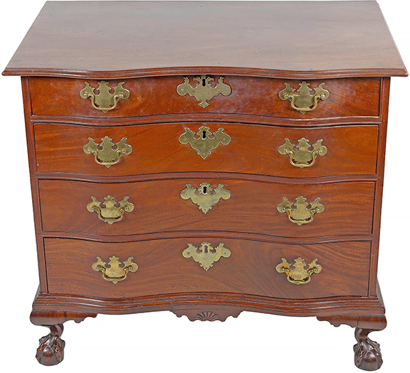 This circa 1770 Boston mahogany oxbow chest is attributed to John Cogswell and sold for $37,800 (est. $30,000/50,000). It has a one-board overhanging top with molded edge, four graduated full-width drawers with cock-bead molding, brasses and escutcheons believed to be original; a molded base with a fan-carved pendant drop, and ball-and-claw feet. The 32&frac34;