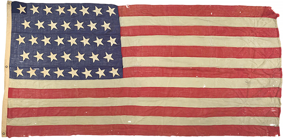 This 38-star hand-sewn American flag commemorating Colorado statehood in 1876, 1877-89, stitched with cotton stars on wool stripes, 69