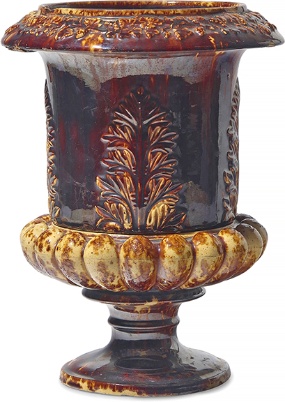 This rare Rockingham-glazed earthenware two-piece flower pot/urn, United States Pottery Co. (1852-58), Bennington, Vermont, 1849-58, the upper section with a hole for drainage, the lower section with a basin for water, 13&frac14;