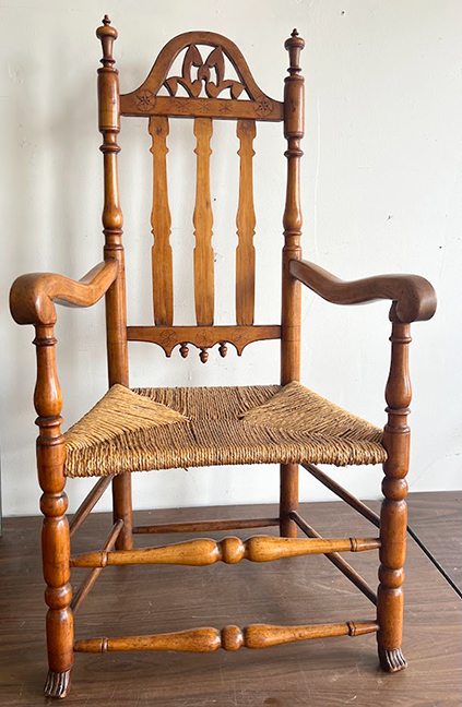 Rare bannister-back armchair with carved pinwheels and paw feet.