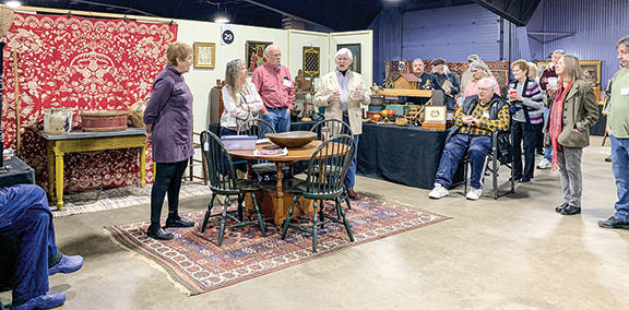 Just before the show opened, exhibitor Steve White (center, in the white jacket) talked about his life and career with his wife, Bev, in the antiques field. Next to Steve were dealers Gene Pratt, Christina Champion, and Jackie Spiegel.