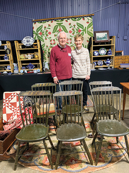 Dave and Mari Crumb of Hilton, New York, posed in their booth, which featured a set of six plank-seat stenciled chairs, $500, and an appliquéd  quilt, $395. There were bargains at this show.