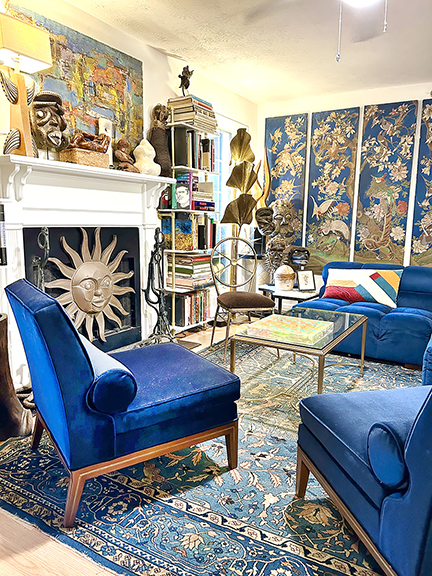 A study in blue in Vieira’s living room. The Tommi Parzinger lounge chairs were reupholstered in Vieira’s favorite shade of blue. On the mantel are a French ceramic work and a wood table lamp, both from Brimfield. On the bookshelf is a pair of Robert Laughlin paintings on hardcover books, found at the 25th Street flea market. The gingko leaf floor lamp is by Tommaso Barbi, and Vieira carried it home on the subway. On the back wall is a four-panel Chinese screen. The carpet is an antique Agra, which Vieira bought at the Scott Antique Markets in Atlanta and then brought back to her New York City apartment.