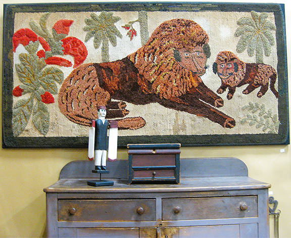 The hooked rug everyone loves—two friendly lions and a bold slash of red—was $1850 from Steve Sherhag of Early American Antiques, Canfield, Ohio. The gray two-drawer cupboard partially shown below was $1750.
