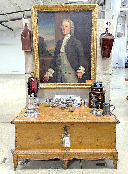 This formal 18th-century portrait of an unknown Virginia Colonist was thought to possibly depict a member of the Byrd or Mercer family. The portrait’s historical provenance is included in a 1960s review done by the Frick Museum, Pittsburgh, Pennsylvania. The review suggests that the portrait was the work of John Hesselius (1728-1778), a portrait painter who worked mostly in Virginia and Maryland. The portrait was tagged $2650 by Peninsula Village Antiques, Peninsula, Ohio. The portrait hangs above an early Mennonite blanket chest priced at $485.