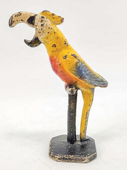 The cast-iron bottle opener in the form of a colorful parrot on its perch does not display any maker’s mark. It stands 5