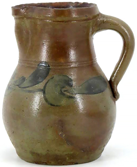 This small bulbous-body stoneware pitcher is unmarked. It has an applied strap handle, stands 8