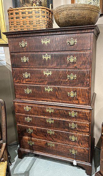 The highly figured Chippendale chest-on-chest, Rhode Island, circa 1770, was $20,000 from Antique Associates at West Townsend, West Townsend, Massachusetts. The 19th-century work basket, possibly Maine, in original bittersweet and black paint and with carved and notched handles, 9½