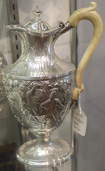 This silver pitcher by London silversmith Paul Storr (1770-1844) dates to 1792. The body of the pitcher features figures, and the neck and base are fashioned in a leaf motif. The high, arching one-piece handle appears to be bone or ivory. The pitcher was marked $3650 by Peter Tinkler of Silver Vault, Woodstock, Illinois.