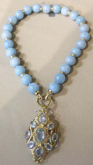 Margaret Alderman Ford of Alderman Ford Fine Estate Jewelry & Antiques, Columbia, South Carolina, offered this necklace, which is a marriage of two 19th-century components. Twenty-five milky aquamarine beads are fitted with a clasp from which is suspended a brooch or pendant that consists of a cluster of nine oval aquamarine stones in an 18k gold setting. The necklace was tagged $16,250.