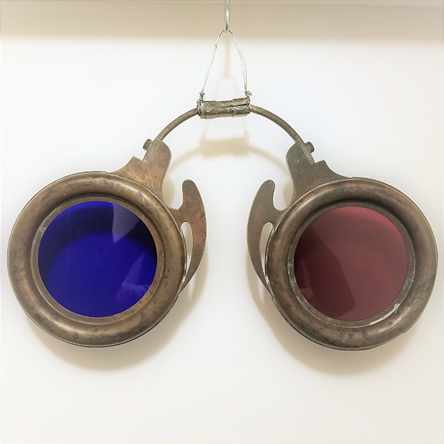 Spectacles with Oxidized Copper and Metal Surface. Original Red and Blue Glass Lenses. Has the Angel Wing Nose Bracket. In very good original condition. Original hanging bracket in place. c. 1880. 20